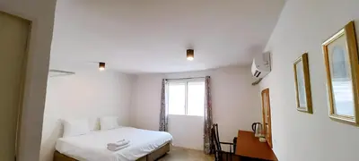 a white bedroom with a bed and a window at Mitr Inn Yaowarat Road in Samphanthawong