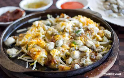 a bowl of pasta with mushrooms and cheese on a table at Mitr Inn Yaowarat Road in Samphanthawong