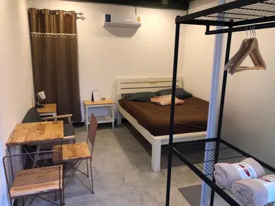 a bedroom with a bunk bed and a table at Bluefin Guesthouse in Bangkok