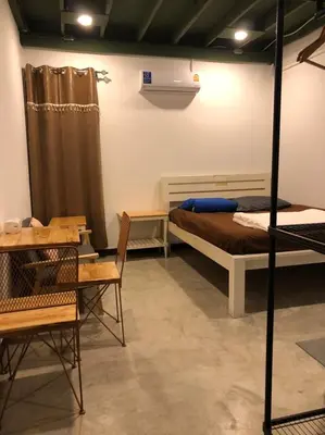 a room with a bed and a table and chairs at Bluefin Guesthouse in Bangkok
