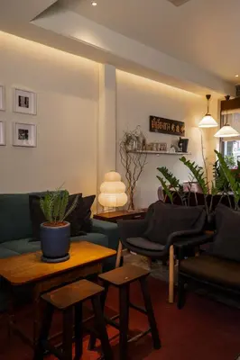 a living room with couches and tables and plants at Nap Old Town in Bangkok