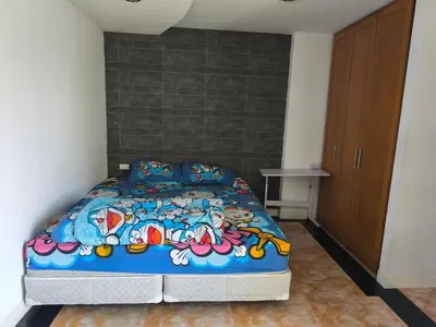 a bedroom with a bed with a colorful comforter at mint apartment in Sathani Bang Su