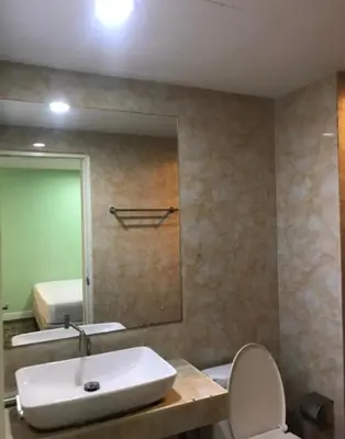 a bathroom with a sink and a toilet and a mirror at mint apartment in Sathani Bang Su