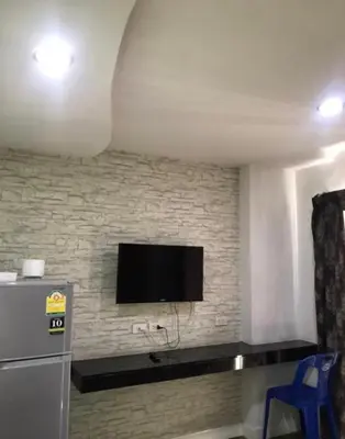 a living room with a tv on a brick wall at mint apartment in Sathani Bang Su