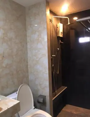 a bathroom with a toilet and a shower stall at mint apartment in Sathani Bang Su