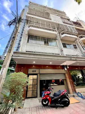 a red scooter parked in front of a building at z Rest Inn Silom - เรสท์ อินน์ สีลม in Bang Rak
