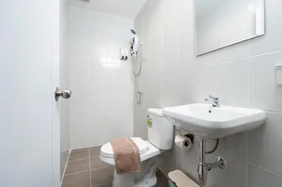 a white bathroom with a toilet and a sink at XX Rest Inn Silom Bangkok in Bang Rak