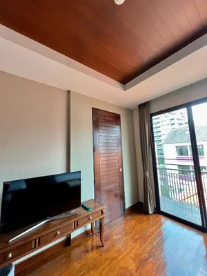 a living room with a large flat screen tv at Yotaka Bangkok Hotel in Bangkok