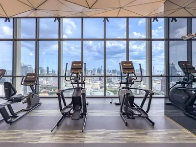 a gym with cardio machines in front of a large window at Luxury Residence in Central of Bangkok Siam Paragon Central World in Pratunam