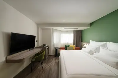a hotel room with a bed and a flat screen tv at The Akyra Bangkok 11 in Bangkok