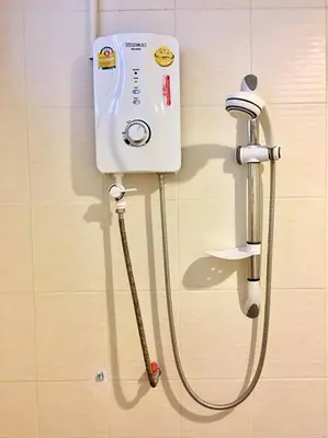 a shower with a hose attached to a wall at Grandview Ladprao Hotel in Bangkok