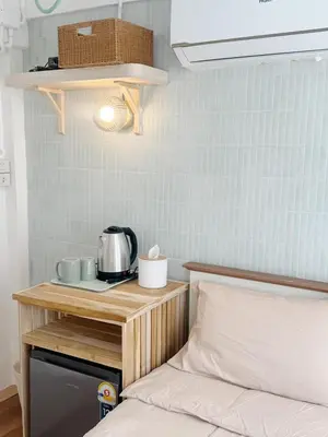 a bedroom with a bed and a table with a toaster at Chatuchak Haus in Bangkok