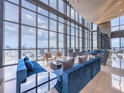 a living room with a blue couch and large windows at New Residence in Central Bangkok Siam Paragon Central World in Pratunam