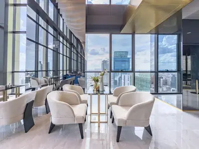 a waiting room with chairs and a table and large windows at New Residence in Central Bangkok Siam Paragon Central World in Pratunam
