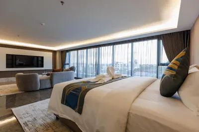 a bedroom with a large bed with a large window at Maritztel Bangkok Hotel in Ban Bang Toei (1)