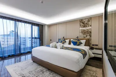 a bedroom with a large bed and a large window at Maritztel Bangkok Hotel in Ban Bang Toei (1)