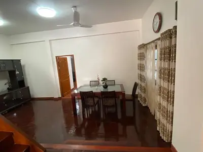 a dining room with a table and a clock on the wall at Beautiful 2 story newly renovated bungalow house in Amphoe Phra Khanong