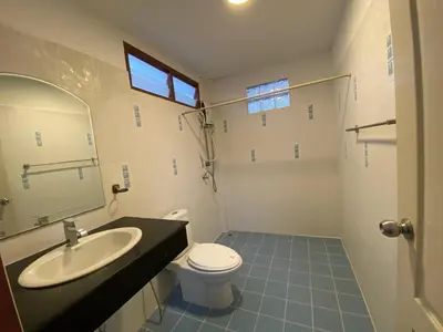 a bathroom with a sink and a toilet and a mirror at Beautiful 2 story newly renovated bungalow house in Amphoe Phra Khanong