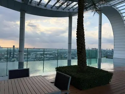 a balcony with a table and a palm tree on a building at The Onnut Nest 1BR Sofa Bed Onnut BTS 50m in Bangkok