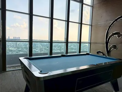 a pool table in a large room with windows at The Onnut Nest 1BR Sofa Bed Onnut BTS 50m in Bangkok