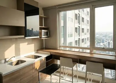 a kitchen with a counter with two chairs and a window at The Onnut Nest 1BR Sofa Bed Onnut BTS 50m in Bangkok
