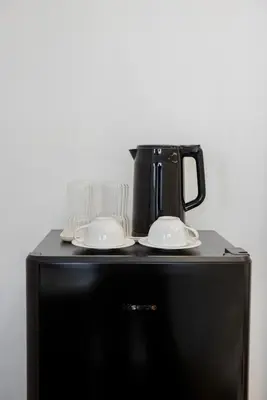 a black appliance with a coffee pot on top of a refrigerator at Luxe apartments in Pratunam
