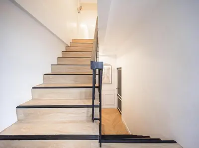 a staircase in a home with white walls and wooden floors at Luxe apartments in Pratunam