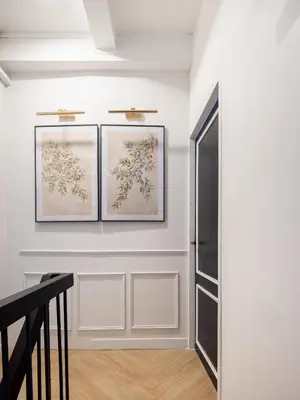 a hallway with three pictures on the wall and a staircase at Luxe apartments in Pratunam