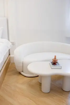 a white living room with a white couch and a table at Luxe apartments in Pratunam