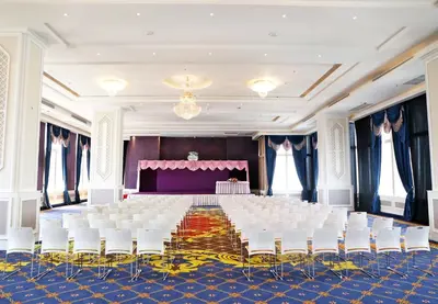 a banquet hall with white chairs and a stage at The Bazaar Hotel Bangkok - MRT Lat Phrao Ratchadapisek in Bangkok