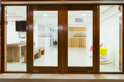a sliding glass door in a room with a table at Thanabhumi in Bangkok