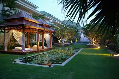 a garden with a gazebo and a pond of flowers at Palette Bangkok Natural Resort and Spa in Bangkok