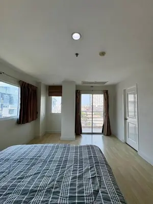 an empty room with a bed and windows at City Living condo at BKK in Bangkok