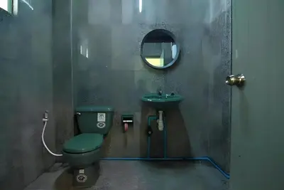 a bathroom with a green toilet and a sink at xx GO INN Grand Palace - โก อินน์ พระบรมมหาราชวัง เจริญกรุง 1 in Bangkok
