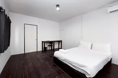 a white bedroom with a bed and a table at xx Mitr Inn Khaosan - มิตร อินน์ ข้าวสาร in Bangkok