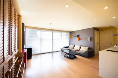 a living room with a couch and a table at Beautiful 1 bed with huge Lumpini park view in Bangkok
