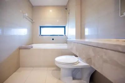 a bathroom with a toilet and a tub and a sink at Beautiful 1 bed with huge Lumpini park view in Bangkok
