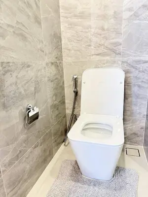 a white toilet in a bathroom with a tile wall at Brand New CONDO near Siam Paragon in Pratunam