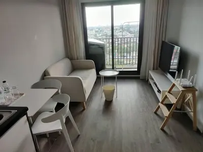 a living room with a couch and a table and a tv at Apartment in Thon Buri 0 meter From BTS station in Bang Khun Thian