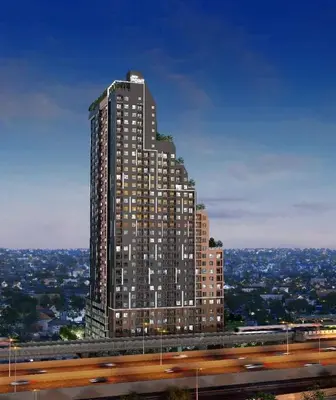 a tall building with lights on in a city at Apartment in Thon Buri 0 meter From BTS station in Bang Khun Thian