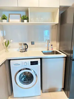 a kitchen with a washing machine and a sink at 2 Bed 2 Bath Condo Steps to BTS&MRT in Bangkok