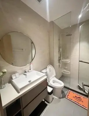 a bathroom with a sink and a toilet and a mirror at Thonglor Ekkamai 10 mins Sky Pool 1BR in Bangkok
