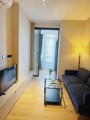 a living room with a couch and a tv at Thonglor Ekkamai 10 mins Sky Pool 1BR in Bangkok