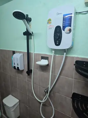 a bathroom with a hair dryer on the wall at 103 Lovely AC apartment with private kitchen in Bangkok