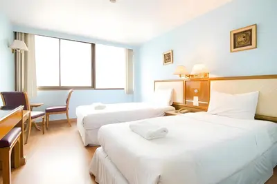 a hotel room with two beds and a desk at xx Wish Inn Chidlom - Ratchadamri 2 in Pratunam