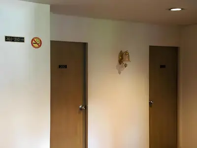 a hallway with two doors and a clock on the wall at xx Wish Inn Chidlom - Ratchadamri 2 in Pratunam