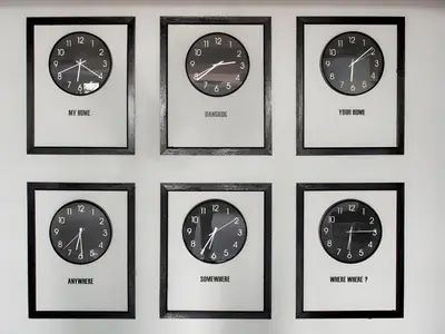 four clocks with different time zones in black frames on a wall at xx Wish Inn Chidlom - Ratchadamri 2 in Pratunam
