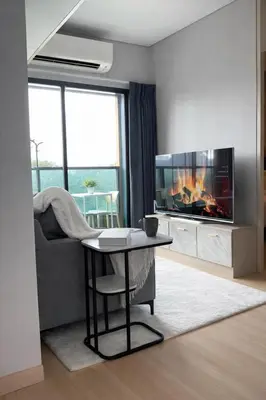 a living room with a table and a fireplace at 2BR Modern Condo Office Room Sofa Bed Pool Gym in Bangkok