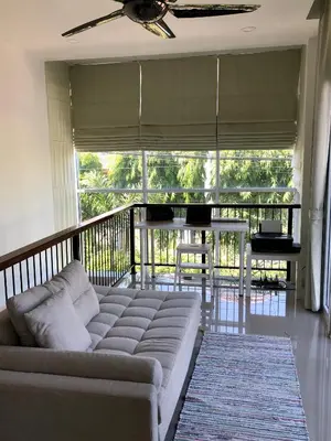 a living room with a couch on a balcony at Cozy and Convenient Bangna House in Ban Khlong Samrong