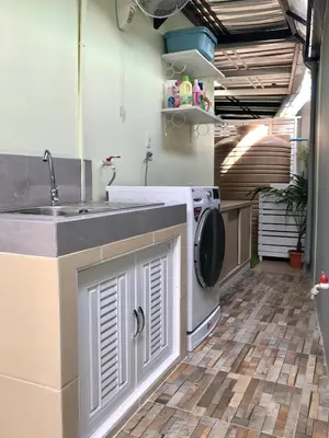 a kitchen with a sink and a washing machine at Cozy and Convenient Bangna House in Ban Khlong Samrong